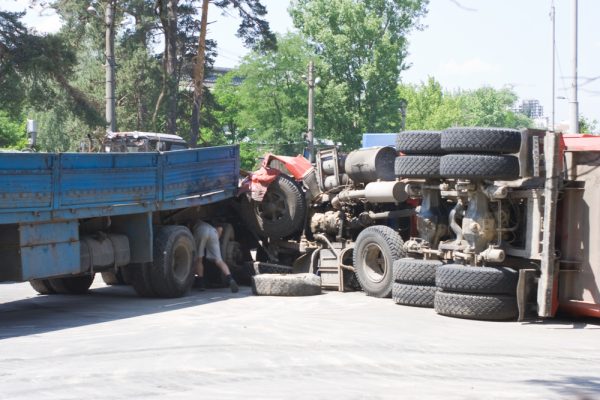 Overturned truck after collision with blue flatbed in urban area