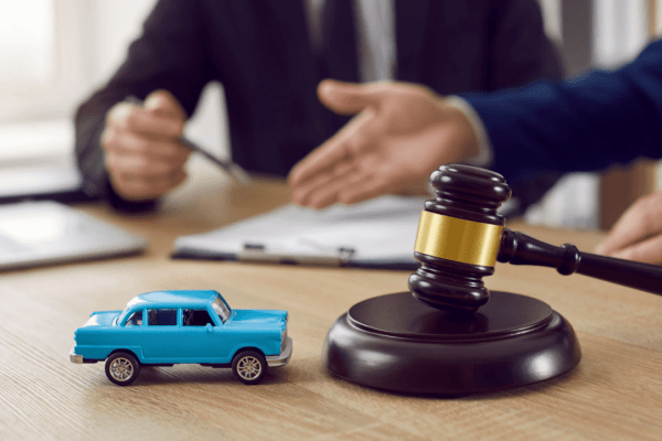 A driver and legal professional complete a commercial vehicle accident report in a law office with a truck visible outside.