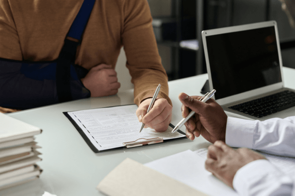 An attorney consults with an injured male client about a commercial vehicle accident case in a Los Angeles law office.