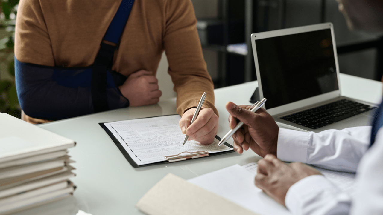 An attorney consults with an injured male client about a commercial vehicle accident case in a Los Angeles law office.
