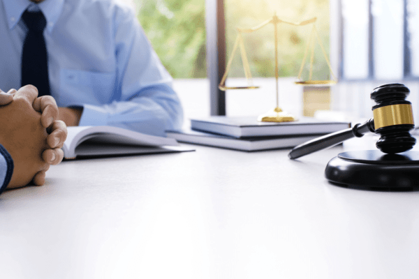 A truck accident attorney and injured client discuss a claim summary in a small-town law office with a truck passing outside the window.