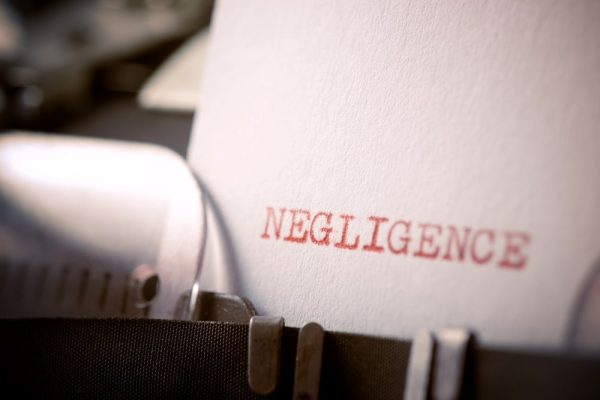 Close-up of the word “Negligence” typed on a white sheet using a vintage typewriter