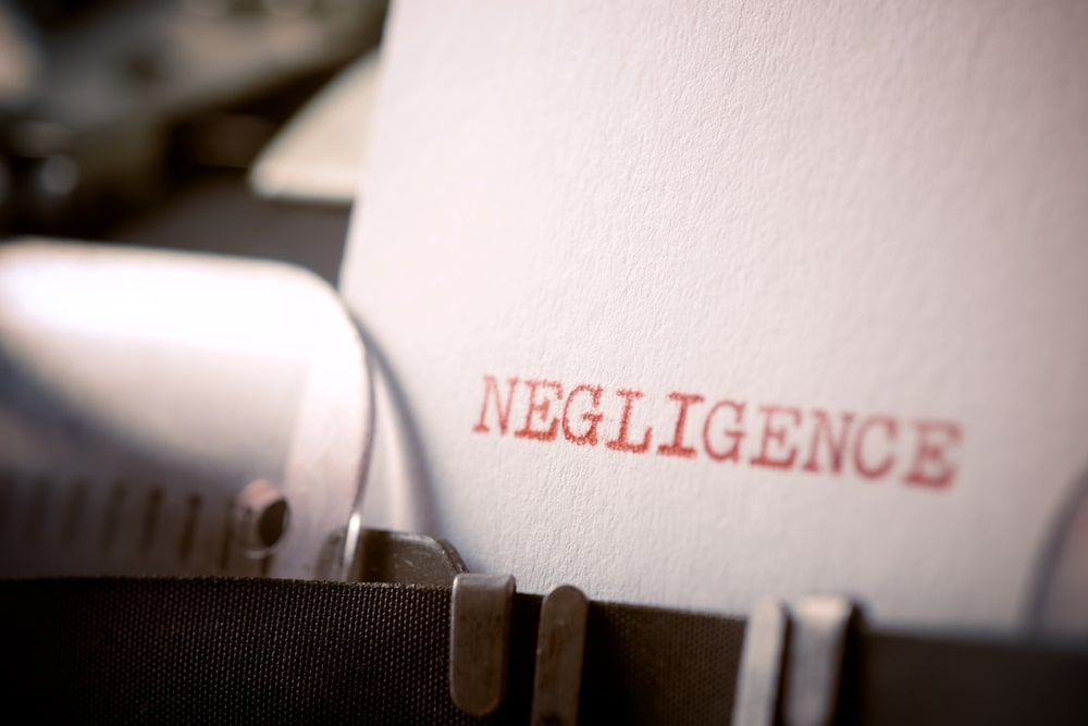 Close-up of the word “Negligence” typed on a white sheet using a vintage typewriter