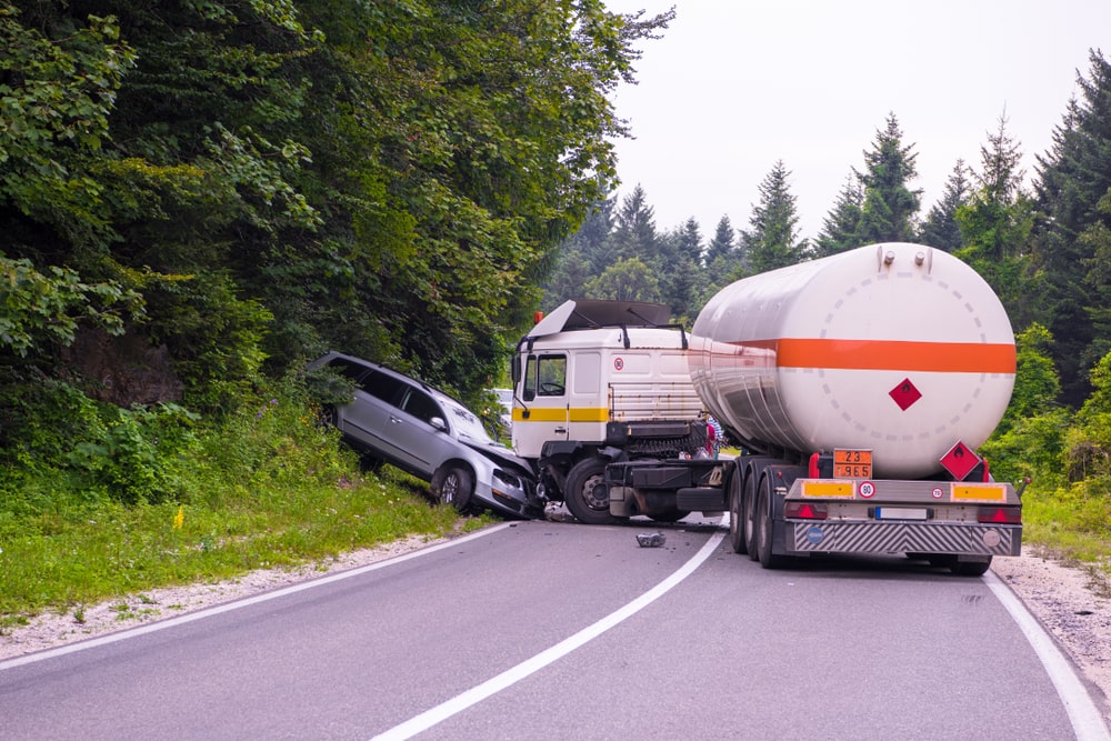 Tank truck and SUV crash on a forested rural road