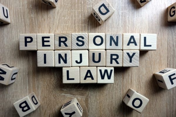 Wooden letter blocks spelling out "Personal Injury Law" on a table