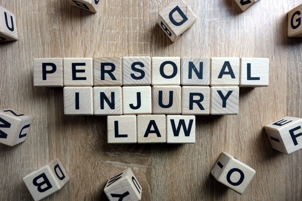 Wooden letter blocks spelling out "Personal Injury Law" on a table