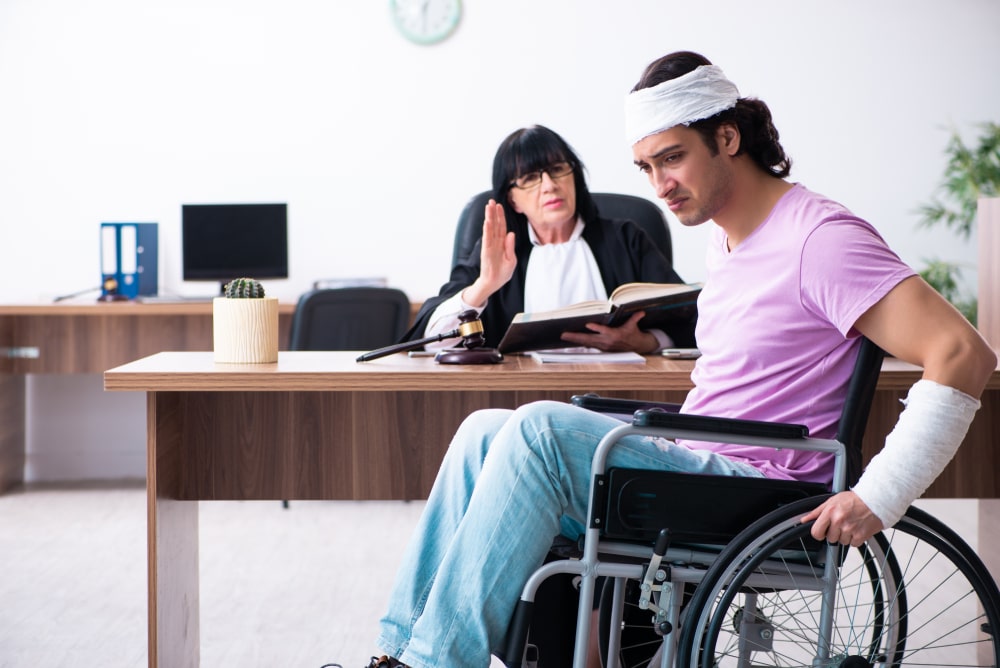 Injured man in wheelchair speaks with attorney after truck accident