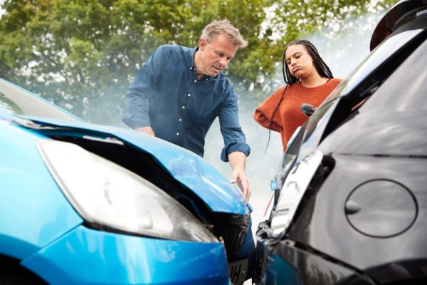 Drivers examining damage after a two-car collision