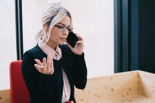 A concerned woman talking on the phone after an accident