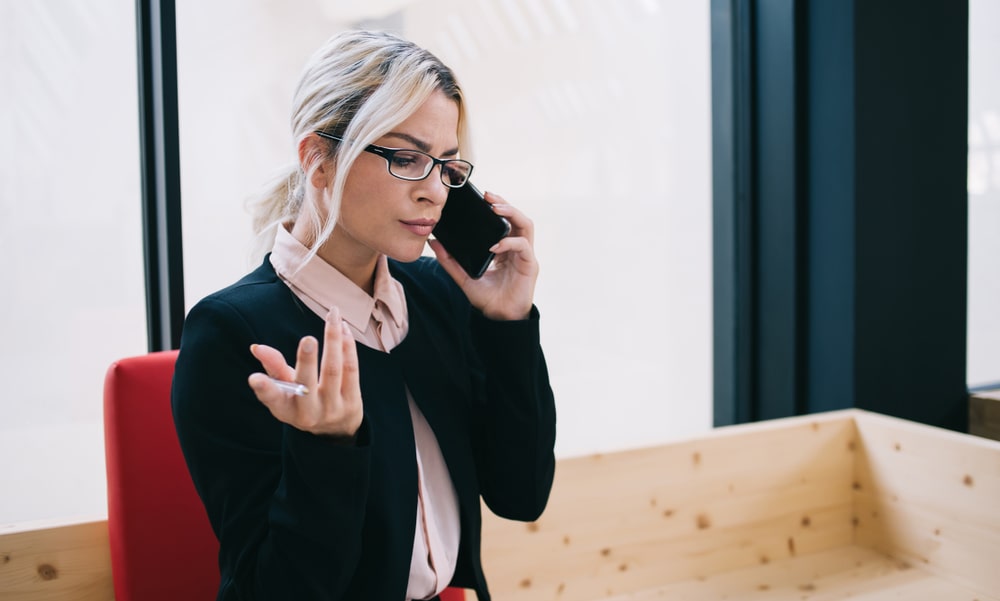 A concerned woman talking on the phone after an accident