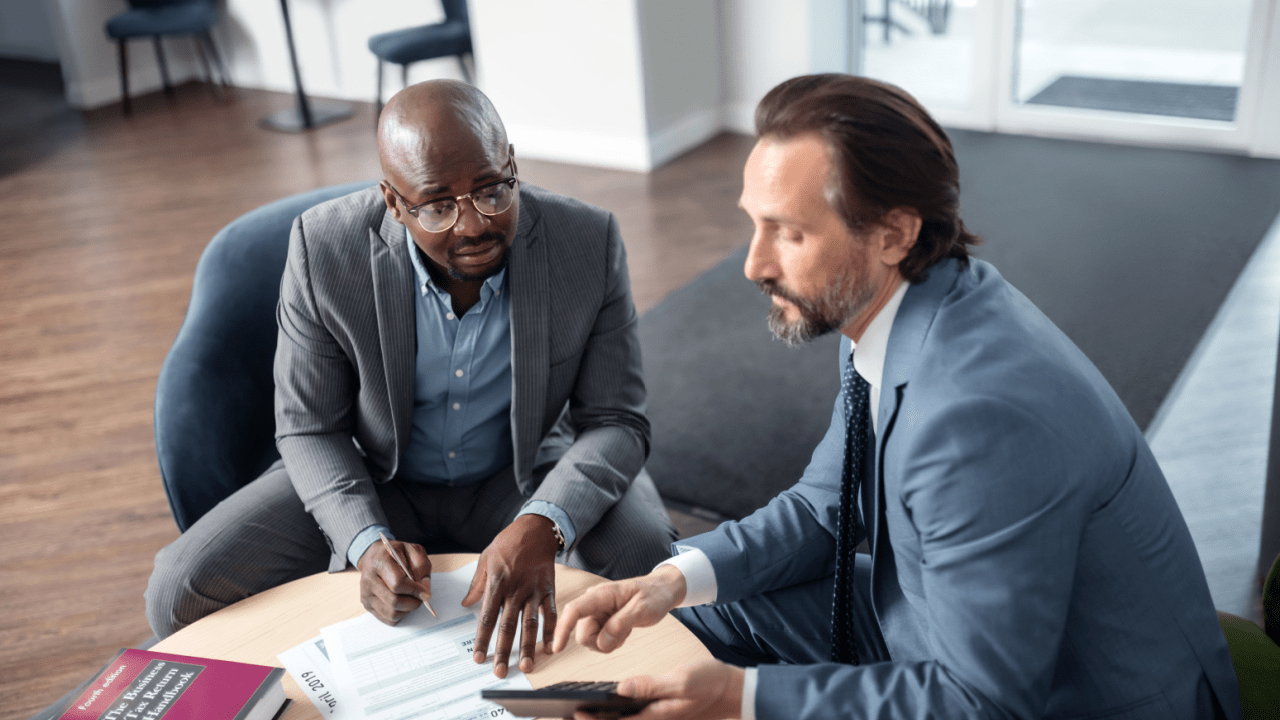 Insurance adjuster and attorney discussing how liability is determined in an accident case with documents and legal papers
