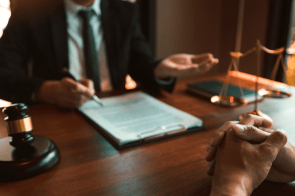 Legal professional consulting about what three things are required to prove negligence with gavel and scales of justice