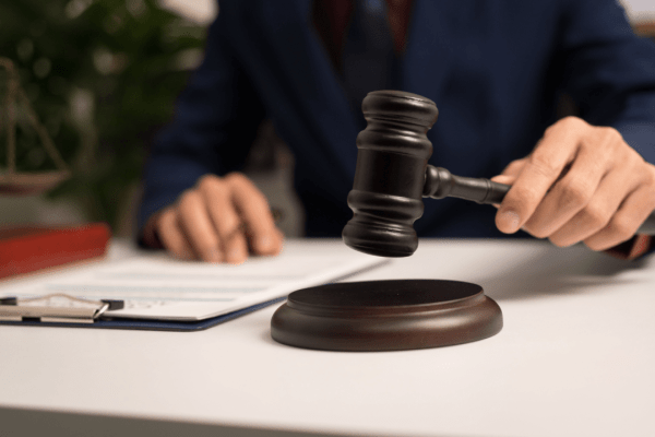 Professional truck accident attorney holding gavel over legal documents in law office