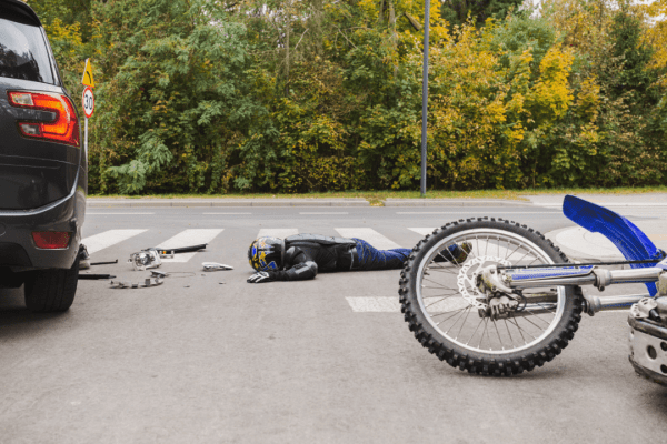 Motorcycle accident scene showing damaged bike and injured rider after collision, illustrating why motorcycle accident settlements vary widely