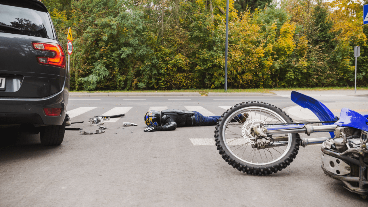 Motorcycle accident scene showing damaged bike and injured rider after collision, illustrating why motorcycle accident settlements vary widely