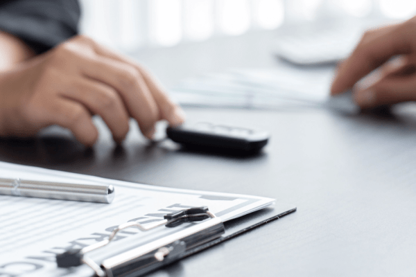 Professional consultation showing how to hire a car accident lawyer with documents and calculator on desk