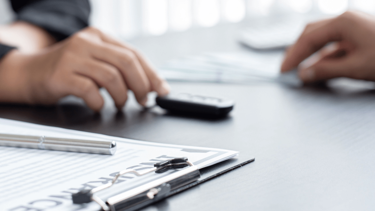 Professional consultation showing how to hire a car accident lawyer with documents and calculator on desk
