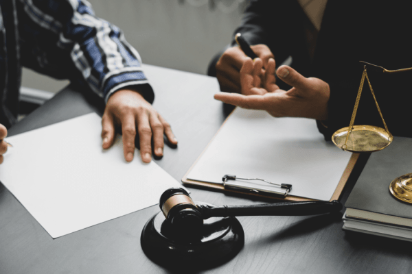 Attorney consulting with client about how much does an accident devalue a truck with legal documents and scales of justice