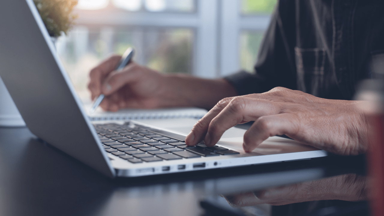 Professional researching costs and affordability of legal help while typing on laptop computer in office setting