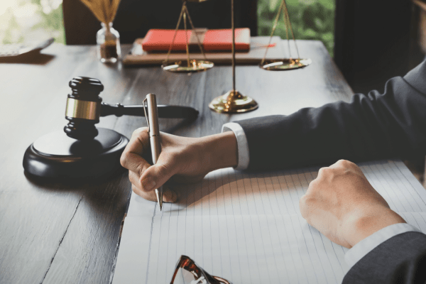 Attorney writing detailed notes about legal fees to help clients understand can I afford a truck accident lawyer