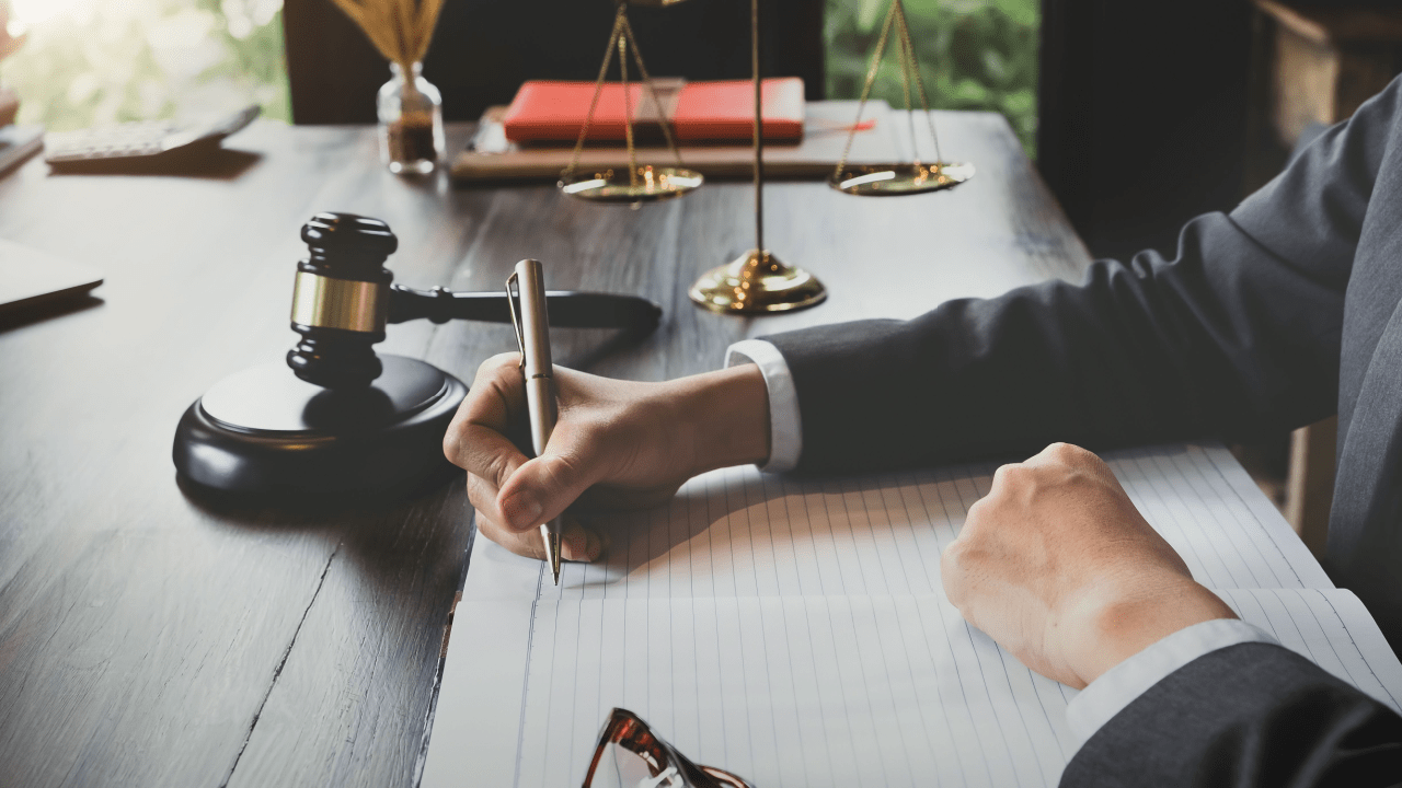 Attorney writing detailed notes about legal fees to help clients understand can I afford a truck accident lawyer