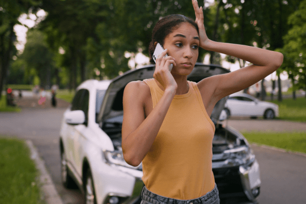 Stressed woman on phone after car accident wondering should you sue after a car accident