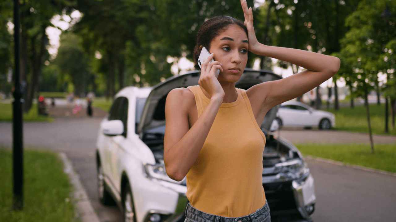 Stressed woman on phone after car accident wondering should you sue after a car accident