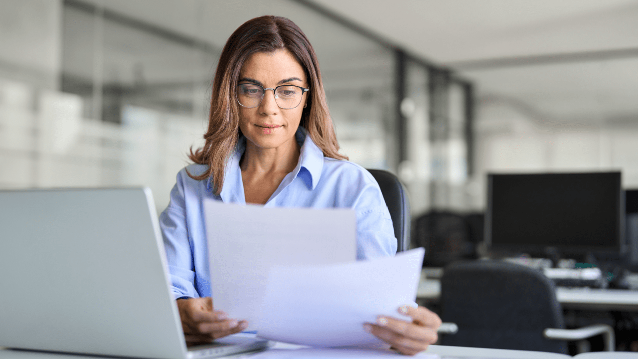 Professional woman reviewing legal documents while considering what not to say to an injury lawyer during consultation