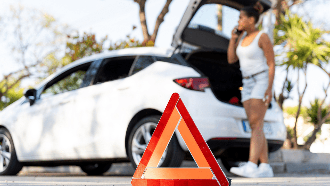 Emergency roadside triangle and woman calling for help - who to contact first after a truck accident emergency situation
