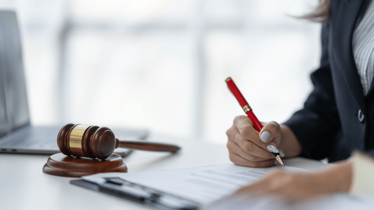 Legal professional reviewing accident lawyer fees and costs documentation with gavel and red pen in law office setting