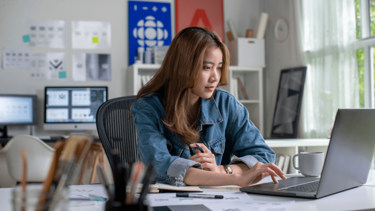 Professional woman researching truck crash compensation on laptop in modern office setting