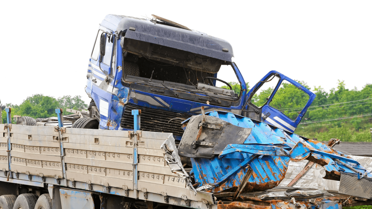 Severely damaged blue truck cab showing why most common injuries in truck accidents are so serious