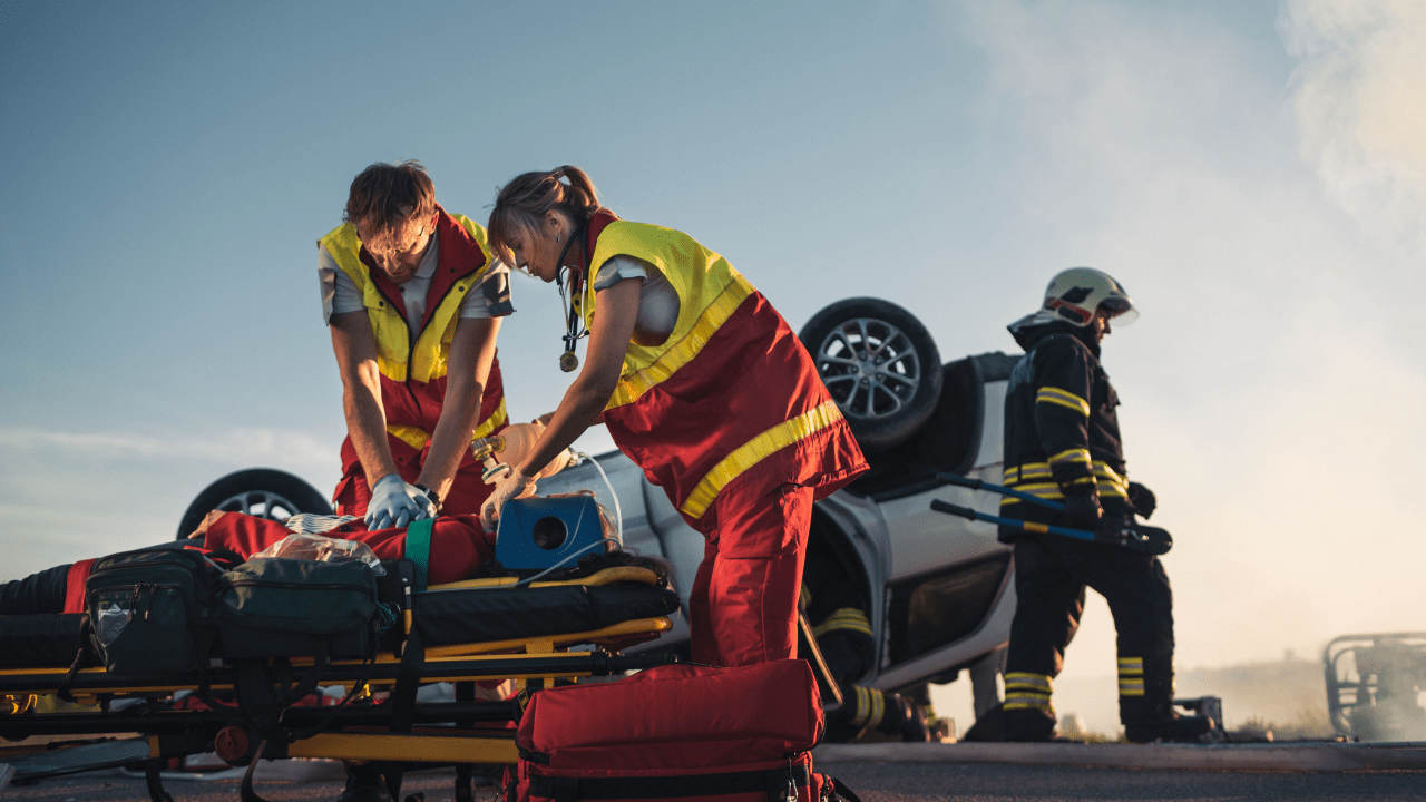 Emergency responders treating car accident victim on stretcher, demonstrating what injury pays the most for a car accident in severe crashes