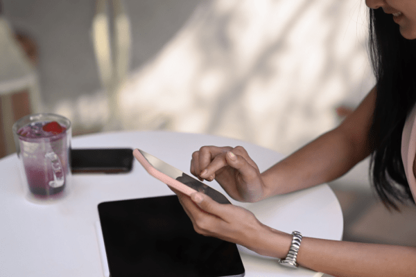 Woman researching does fault affect accident compensation on smartphone while sitting at table