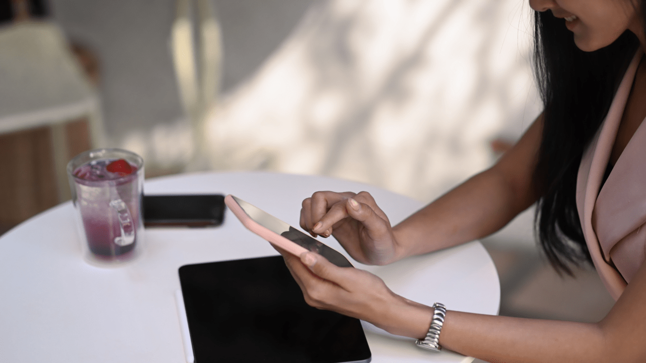 Woman researching does fault affect accident compensation on smartphone while sitting at table