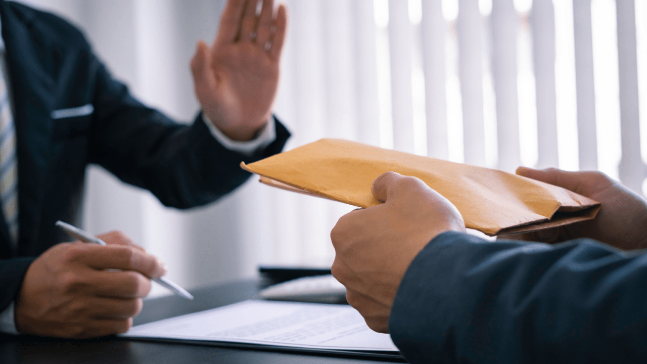 Professional declining settlement envelope showing how do you get paid from a car accident settlement negotiations