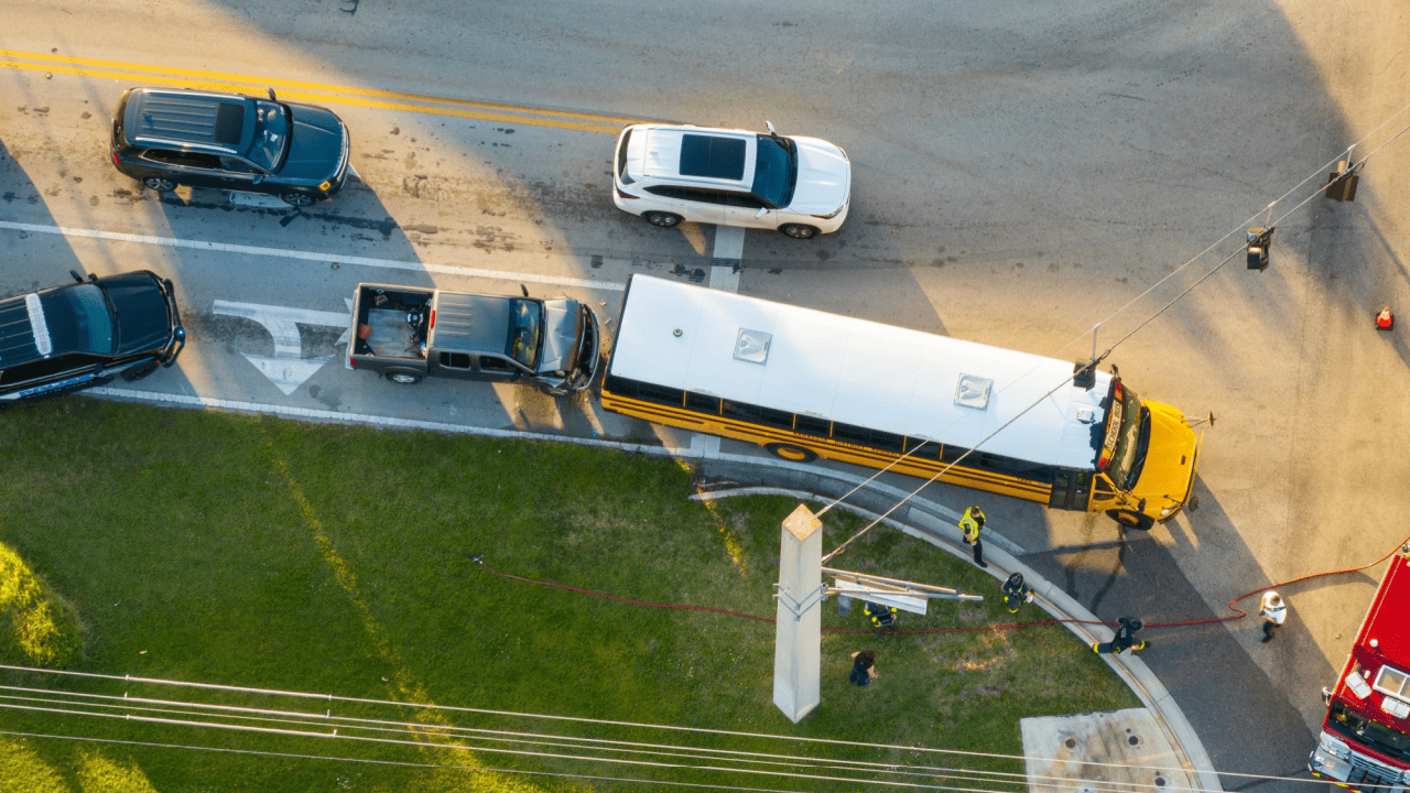 Aerial view of school bus at intersection with utility workers demonstrating what is the DOT rule 49 CFR for commercial vehicle operations and road safety compliance