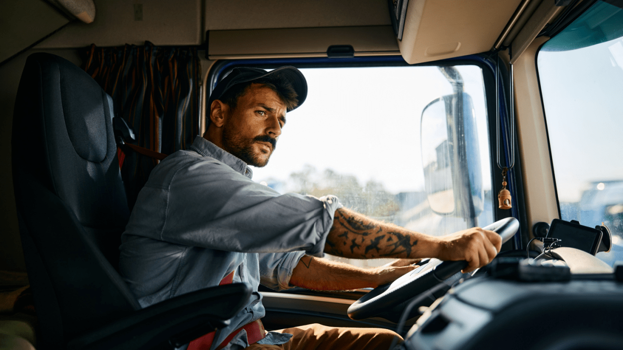 Professional truck driver in cab demonstrating compliance with DOT trucking regulations