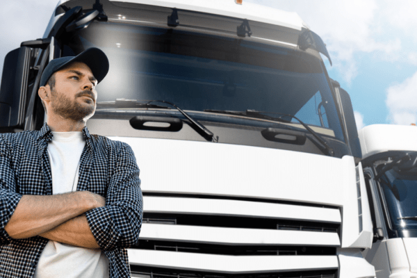 Professional truck driver standing confidently by commercial truck representing truck safety and restrictions