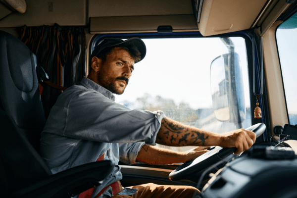 Professional truck driver in cab demonstrating what can truck drivers not do under federal regulations