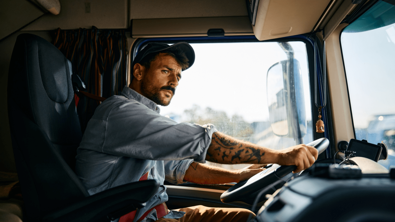 Professional truck driver in cab demonstrating what can truck drivers not do under federal regulations