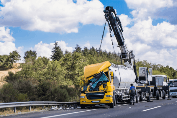 How to negotiate a higher truck accident settlement shown through severe truck damage requiring crane removal on highway