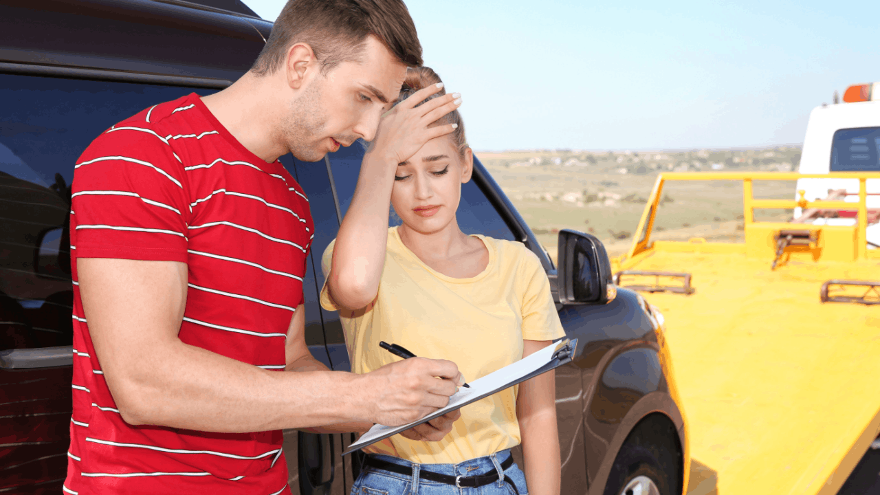 Truck accident settlement process begins as stressed couple exchanges insurance information after highway collision