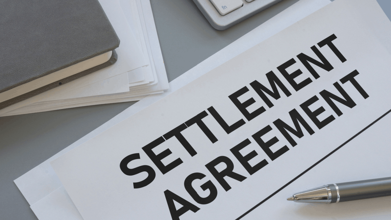 Typical settlement ranges for different types of accidents documented in a settlement agreement on an office desk with a pen