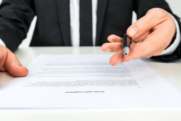 What to ask for in a truck accident settlement shown through attorney reviewing terms and conditions document with legal contract