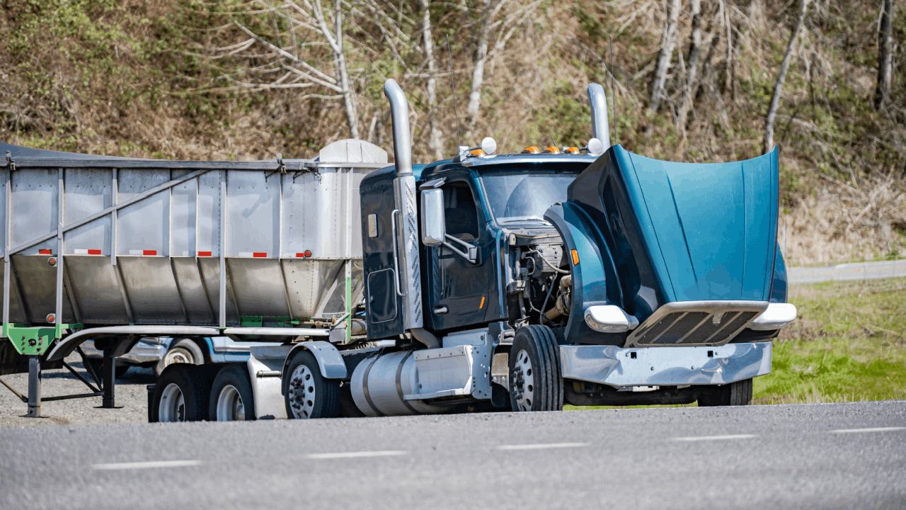 Does liability mean fault in a truck accident scene with damaged blue semi-truck and dump trailer on rural roadway