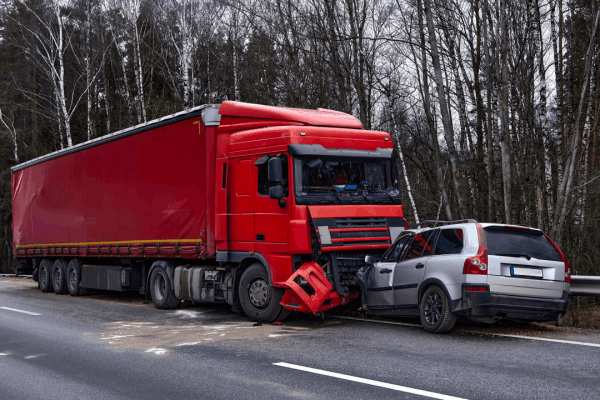 Red commercial truck collided with passenger vehicle demonstrating how fault is determined in truck accidents through crash scene evidence