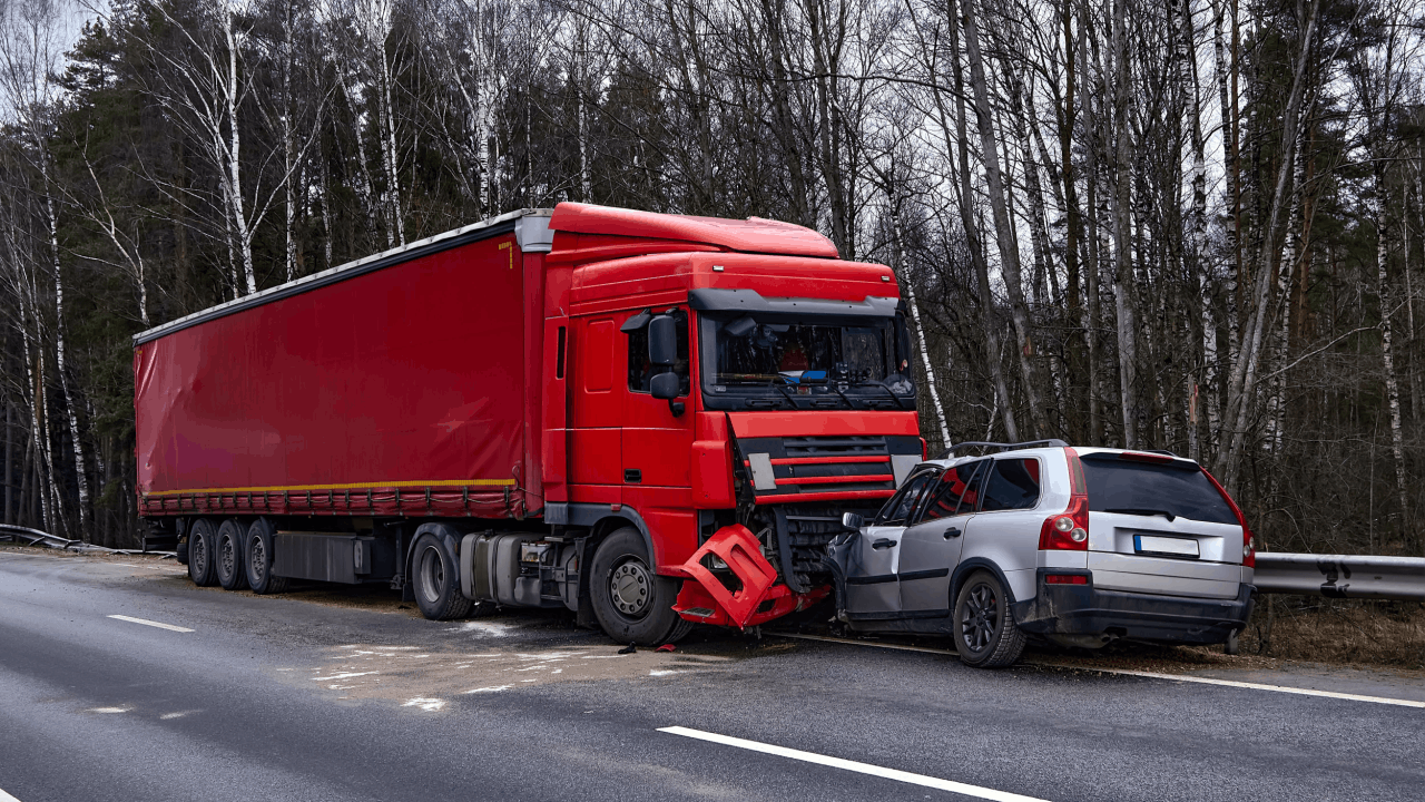 Red commercial truck collided with passenger vehicle demonstrating how fault is determined in truck accidents through crash scene evidence