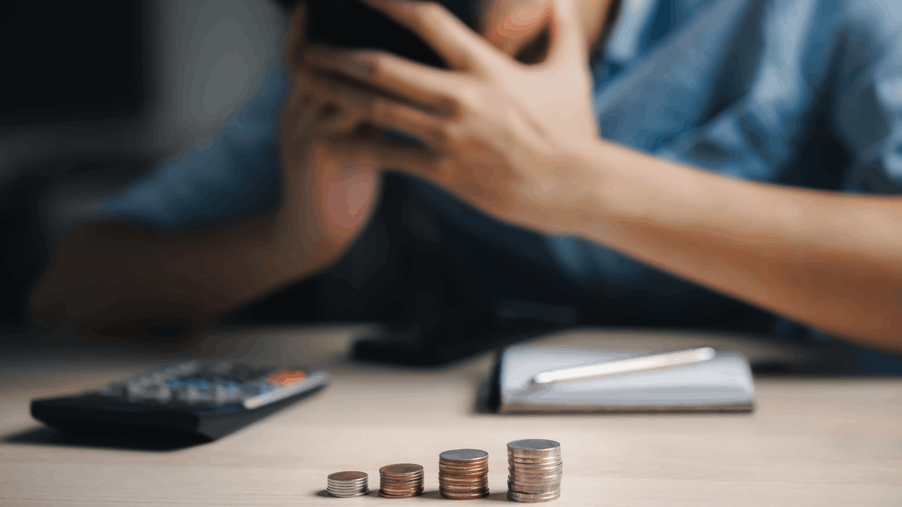 Loss of income after accident — stressed person with stacked coins on table