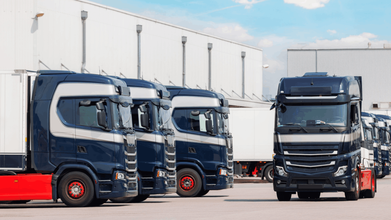 Commercial semi-trucks at trucking facility showing vehicles covered by liability insurance when truck accidents occur
